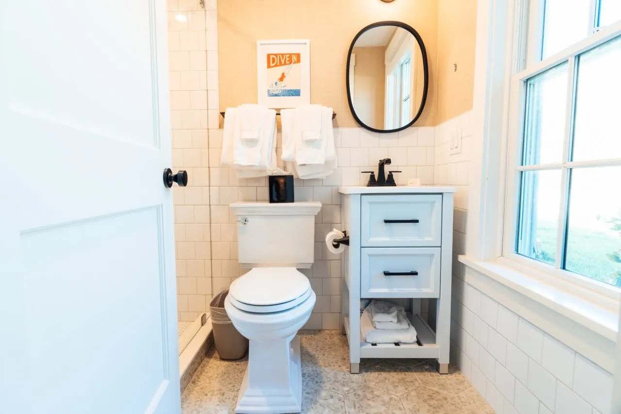 Bright bathroom at Franklin Hotel with white walls, toilet, and small vanity
