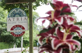 Atria Island Dining sign with flowers and trees in the background