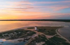 Drone view of Edgartown Lighthouse and coastline at dusk with colorful sky
