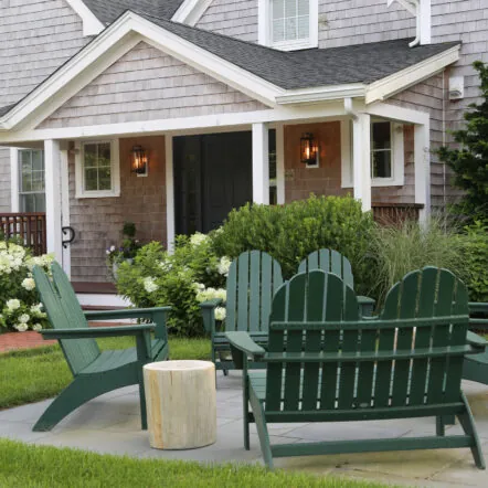 Exterior Front of Franklin Hotel with outdoor seating area, green chairs and garden.