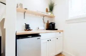 Small kichenette at Franklin Hotel with coffee makers, mini fridge and wooden shelf