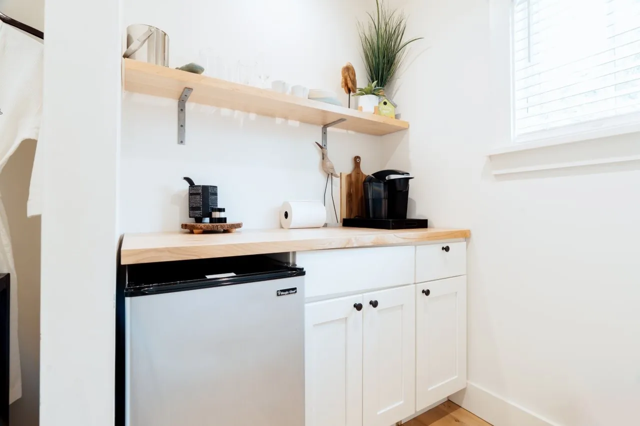 Small kichenette at Franklin Hotel with coffee makers, mini fridge and wooden shelf