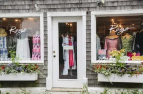 Rags boutique shop with dresses displayed in windows and wooden shingle exterior