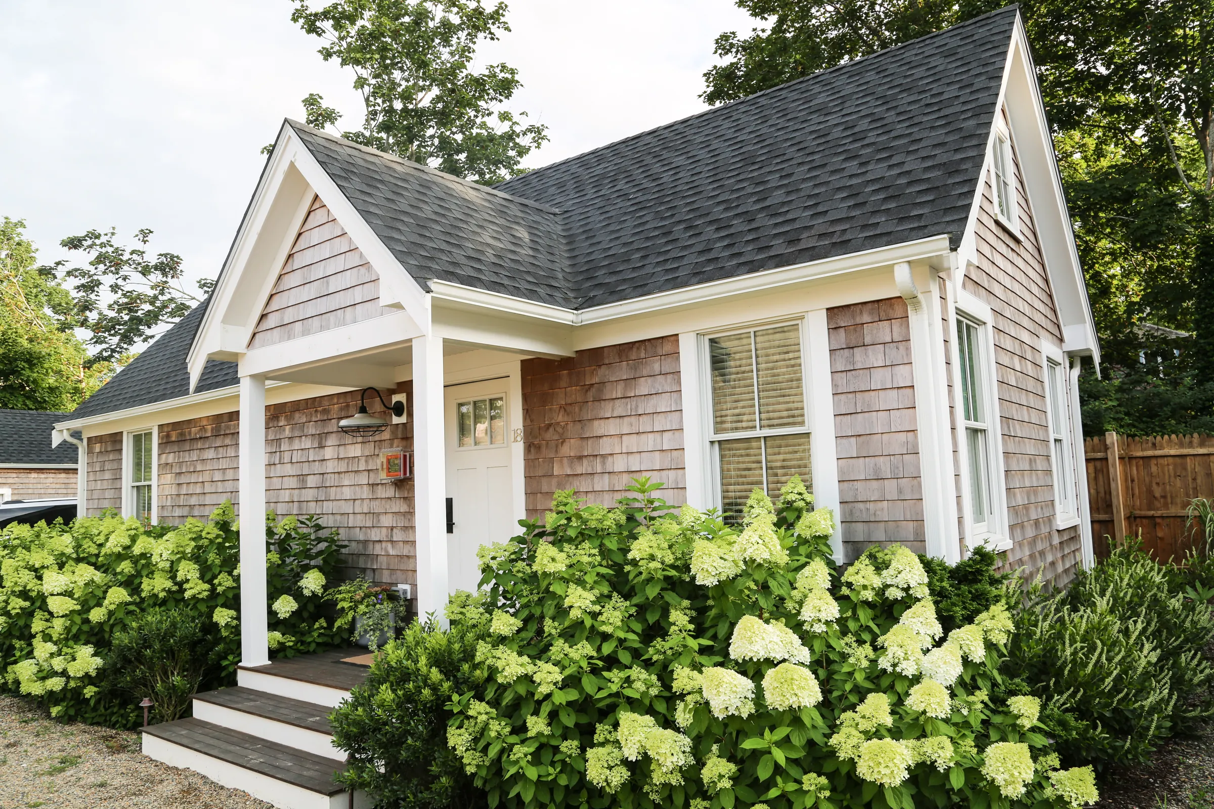 Cottage with front porch and blooming flowers