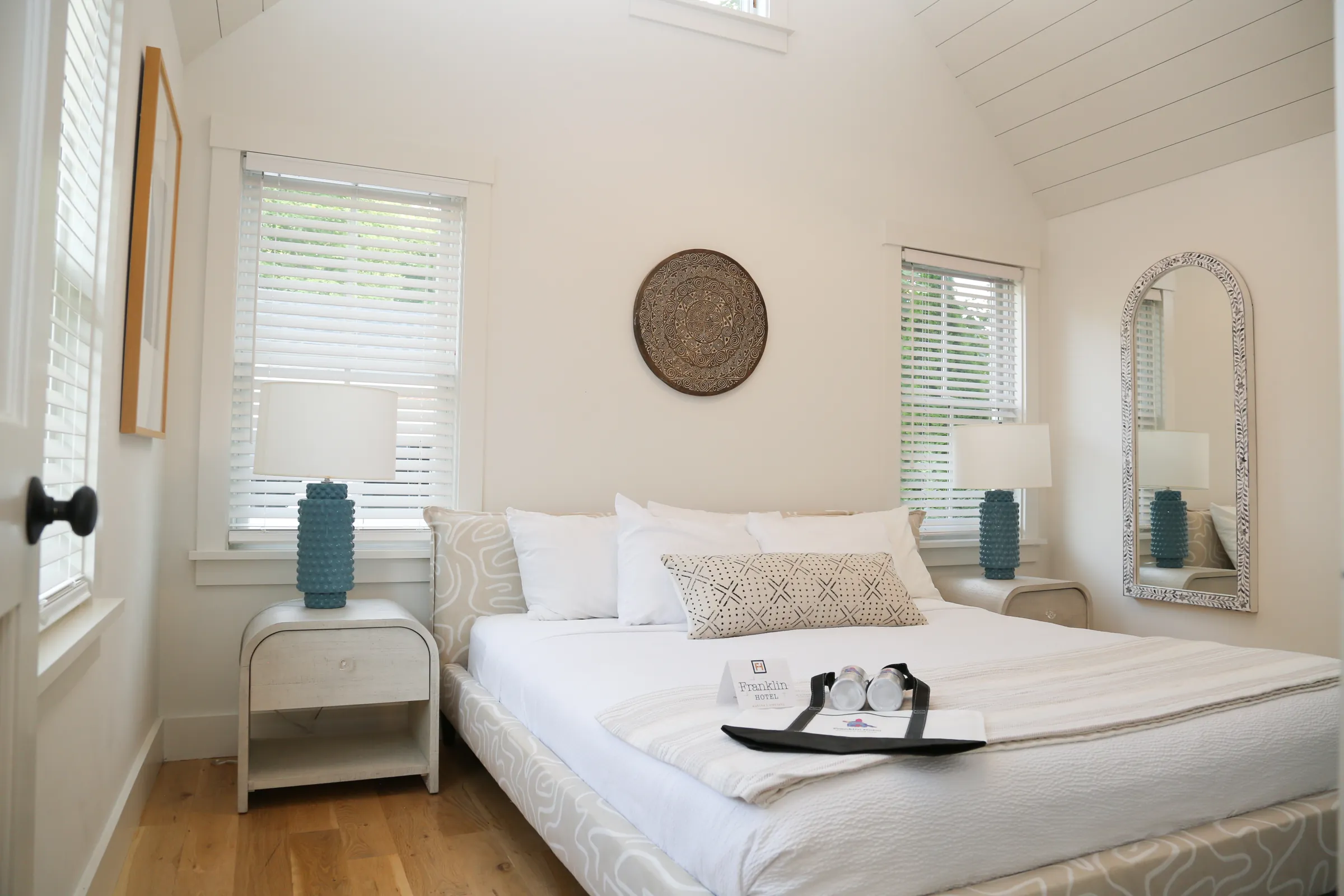 Bedroom with white bed, blue lamps and natural light